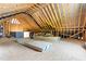 Spacious unfinished attic with exposed wooden beams and layered insulation, offering potential for customization at 529 Lake Gaston Dr, Fuquay Varina, NC 27526