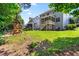 A large backyard with a playset, a patio, and trees, ideal for a Gathering to play outside at 529 Lake Gaston Dr, Fuquay Varina, NC 27526
