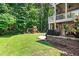 A spacious backyard with a playset, built-in grill area, and mature trees for shade and privacy at 529 Lake Gaston Dr, Fuquay Varina, NC 27526