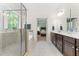 Bright bathroom featuring a glass shower, soaking tub, and double vanity with dark wood cabinets at 529 Lake Gaston Dr, Fuquay Varina, NC 27526