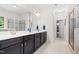 Bathroom with a dual vanity featuring dark wood cabinets, a large mirror, and a glass door shower at 529 Lake Gaston Dr, Fuquay Varina, NC 27526