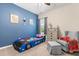 A themed bedroom with a blue accent wall, colorful car-shaped bed, and comfortable reading area at 529 Lake Gaston Dr, Fuquay Varina, NC 27526