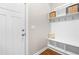 Mud room with white storage bench and hooks near a white door and wood floors at 529 Lake Gaston Dr, Fuquay Varina, NC 27526