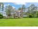 Expansive backyard featuring a well-manicured lawn, a deck for entertaining, and mature trees at 53 Lake Wendell Rd, Wendell, NC 27591