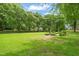 Lush backyard with gardening beds and mature trees, perfect for outdoor activities and relaxation at 53 Lake Wendell Rd, Wendell, NC 27591