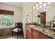 Inviting bathroom featuring a granite countertop, decorative mirror, and a window overlooking the trees at 53 Lake Wendell Rd, Wendell, NC 27591