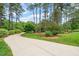 Long driveway leading to a stunning home surrounded by lush greenery and mature trees at 53 Lake Wendell Rd, Wendell, NC 27591