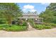 Charming two-story home features a covered porch, landscaped yard, and a picturesque bridge entrance at 53 Lake Wendell Rd, Wendell, NC 27591