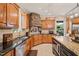 Gourmet kitchen showcases wood cabinets, stone range hood, granite counters, and stainless steel appliances at 53 Lake Wendell Rd, Wendell, NC 27591
