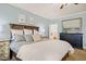Comfortable main bedroom featuring wooden furniture, soft blue walls, and a glimpse of the ensuite bathroom at 53 Lake Wendell Rd, Wendell, NC 27591