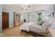 Bright main bedroom with a sitting area, large windows and an elegant display cabinet at 53 Lake Wendell Rd, Wendell, NC 27591