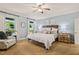 Serene bedroom features a large bed, soft lighting, and windows overlooking the backyard at 53 Lake Wendell Rd, Wendell, NC 27591
