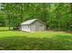 Detached one-car garage/shed with a white exterior and surrounded by lush greenery at 53 Lake Wendell Rd, Wendell, NC 27591