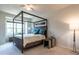 Bright bedroom with a four-poster bed, ceiling fan, and a large window with natural light at 6147 Beale Loop, Raleigh, NC 27616