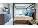 Bedroom featuring a four-poster bed, dresser, and large windows offering ample natural light at 6147 Beale Loop, Raleigh, NC 27616