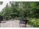 An outdoor patio area furnished with chairs, providing a relaxed space surrounded by lush greenery and trees at 6147 Beale Loop, Raleigh, NC 27616