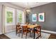 Bright dining room featuring a modern light fixture, wood table, and gray accent wall with artwork at 644 Granite Mill Blvd, Chapel Hill, NC 27516