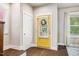 Bright entryway featuring a yellow front door, wood floors, white trim, and natural light at 644 Granite Mill Blvd, Chapel Hill, NC 27516