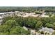 A high-angle shot reveals tree-lined streets, surrounding retail and townhome community at 7159 Sandy Creek Dr, Raleigh, NC 27615