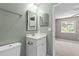 Updated bathroom with a single sink vanity, a mirror, and modern fixtures near a bedroom at 7159 Sandy Creek Dr, Raleigh, NC 27615