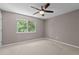 Bedroom with an oversized window to bring in lots of natural light and carpet flooring at 7159 Sandy Creek Dr, Raleigh, NC 27615
