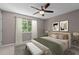 Well-lit bedroom with a large window, modern ceiling fan, and stylish decor at 7159 Sandy Creek Dr, Raleigh, NC 27615