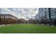 Expansive green lawn surrounded by apartment buildings, pedestrian walkways, and mature trees at 7159 Sandy Creek Dr, Raleigh, NC 27615