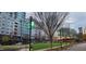 Serene community park with grassy lawn, walking paths, and modern apartment buildings in the background at 7159 Sandy Creek Dr, Raleigh, NC 27615