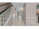Bright hallway with tile flooring, white stairs, and neutral paint at 7159 Sandy Creek Dr, Raleigh, NC 27615
