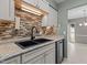 The sink shows black fixtures, granite countertops and tiled backsplash with ample cabinets and lighting at 7159 Sandy Creek Dr, Raleigh, NC 27615