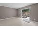 Living room with a sliding glass door leading to a patio area with a wooden fence at 7159 Sandy Creek Dr, Raleigh, NC 27615