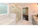 Bathroom boasts tub, shower, and double granite vanity with view of a bedroom in the background at 723 Lindley Dr, Durham, NC 27703