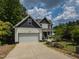 Charming two-story home featuring white siding, a gray roof, an attached two-car garage, and a well-maintained front lawn at 723 Lindley Dr, Durham, NC 27703