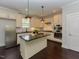 Well-lit kitchen with white cabinets, stainless steel appliances, a center island, and hardwood floors, perfect for cooking at 723 Lindley Dr, Durham, NC 27703