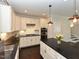 Bright kitchen with white cabinets, black countertops, stainless steel appliances, and elegant pendant lighting at 723 Lindley Dr, Durham, NC 27703