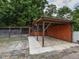 Rustic outdoor structure with a stone patio, offering a shaded area for relaxation or entertainment in a natural setting at 723 Lindley Dr, Durham, NC 27703
