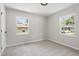 Cozy bedroom with neutral carpeting and paint, and natural light from two windows at 768 Lunar Dr, Raleigh, NC 27610