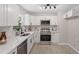 Bright kitchen featuring stainless steel appliances, quartz countertops, and neutral backsplash at 768 Lunar Dr, Raleigh, NC 27610