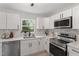 Updated kitchen features stainless steel appliances, white cabinets, and views of the yard at 768 Lunar Dr, Raleigh, NC 27610