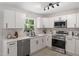 Modern kitchen with stainless steel appliances, white cabinets, and quartz countertops at 768 Lunar Dr, Raleigh, NC 27610