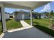 View from the covered patio of a green lawn, detached garages and matching landscaping at 805 Portland Rose Dr, Knightdale, NC 27545