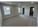 Spacious bedroom with plush carpet, large windows for natural light, and a ceiling fan at 805 Portland Rose Dr, Knightdale, NC 27545