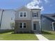 Charming two-story home with a combination of brick and siding on a beautiful lawn with a clear blue sky at 805 Portland Rose Dr, Knightdale, NC 27545