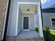 Front door to the house with brick foundation, gray siding, and white trim, with house number 805 at 805 Portland Rose Dr, Knightdale, NC 27545