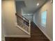 Hallway and carpeted stairs with white banisters and black metal spindles at 805 Portland Rose Dr, Knightdale, NC 27545