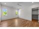 Bedroom featuring hardwood floors, neutral walls, two windows, a ceiling fan, and a walk-in closet at 805 Tower St, Raleigh, NC 27607