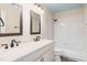 Well-lit bathroom with double sink vanity, decorative mirrors, and shower-tub combination at 809 Green Passage Ln, Apex, NC 27502