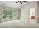 Bedroom with neutral walls, plush carpeting, ceiling fan, built-in shelving, and attached bathroom at 809 Green Passage Ln, Apex, NC 27502