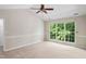 Spacious bedroom featuring neutral walls, plush carpeting, ceiling fan, and large window with green view at 809 Green Passage Ln, Apex, NC 27502
