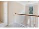 Bright hallway with white railing, light fixture, and large window letting in natural light at 809 Green Passage Ln, Apex, NC 27502